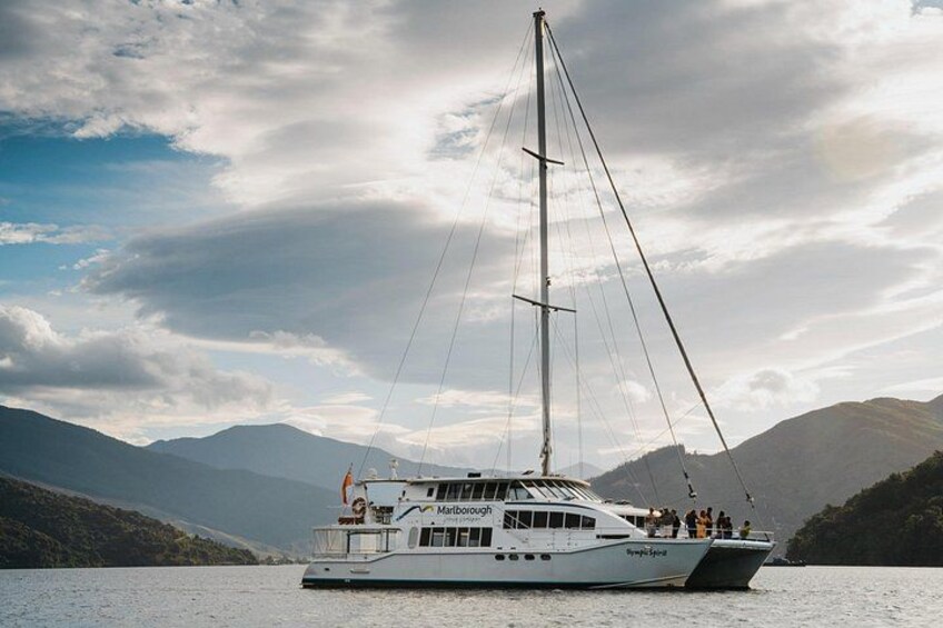 A white yacht named 'Marina' on a lake with mountains in the background. 2