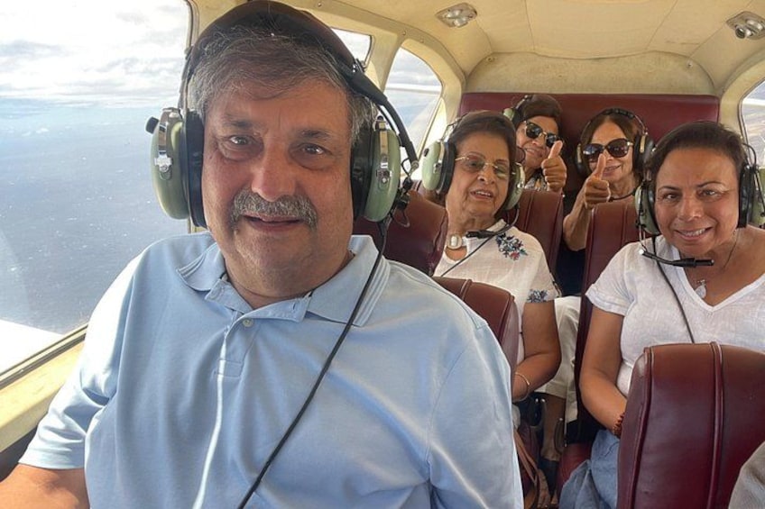 Un grupo de personas dentro de la cabina de un avión, con vistas al cielo y nubes. 2