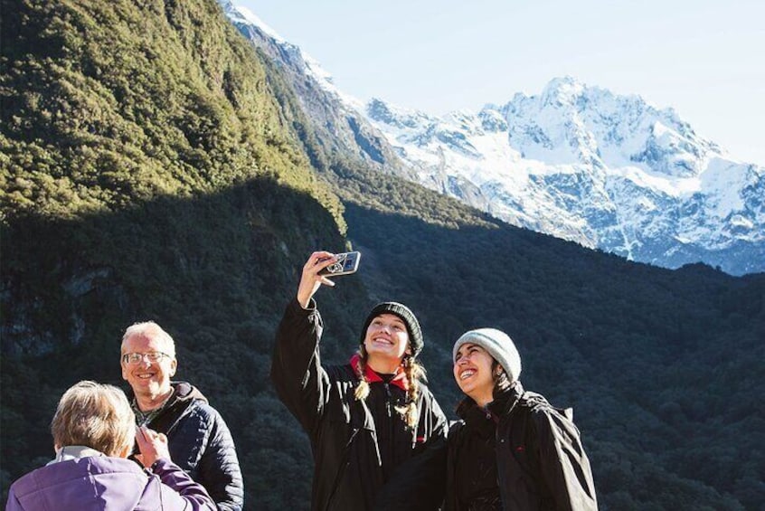 En grupp människor som tar ett foto med ett bergskedja i bakgrunden. 4