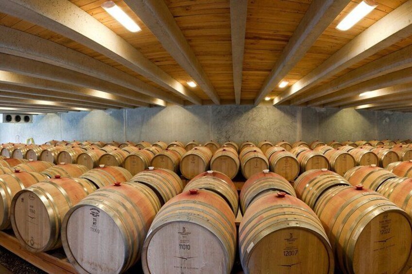 A wine cellar with rows of wooden barrels. 3