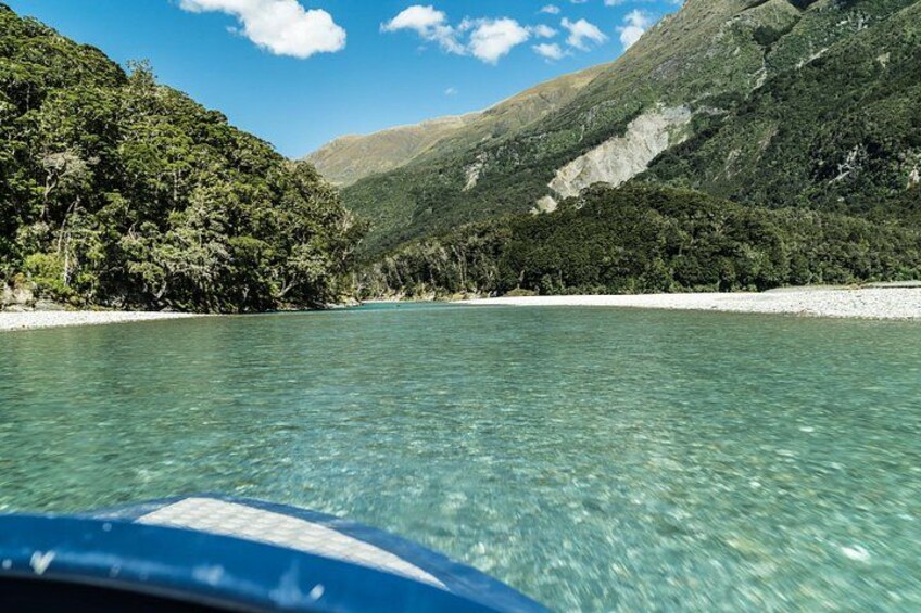 A clear lake surrounded by forested hills. 5