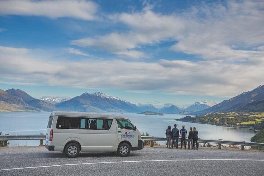 Ein weißer Van steht an einem See, im Hintergrund Berge. 4