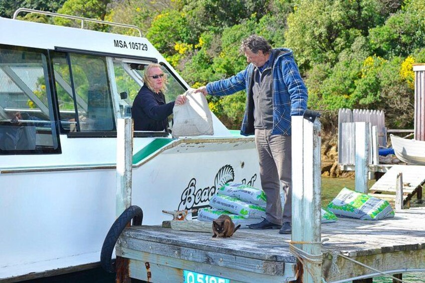 A man unloading bags from a boat named 'Becca' at a dock. 2