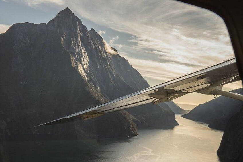 Une aile d’avion, un paysage montagneux et une étendue d’eau. 2
