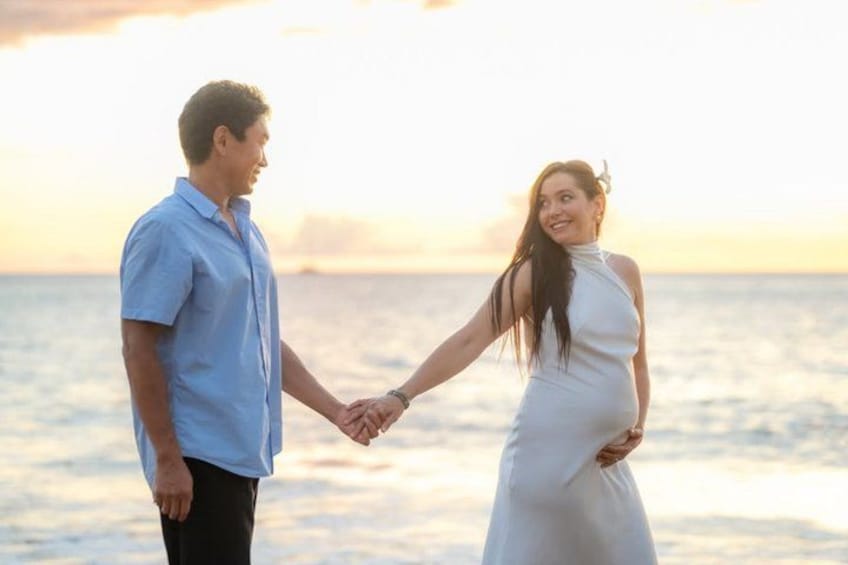 Una pareja tomados de la mano en una playa al atardecer. 2