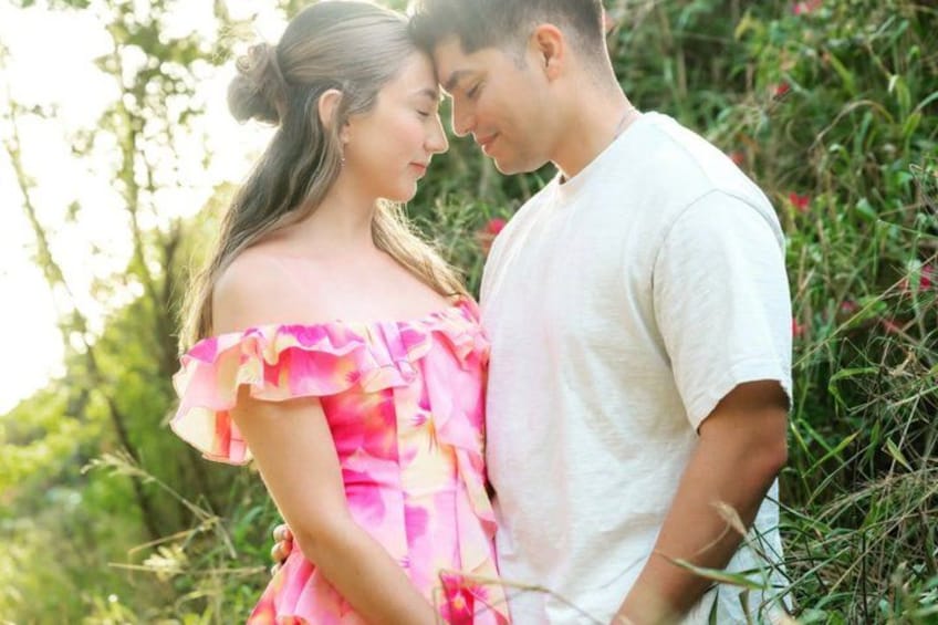 Una pareja de pie en un jardín lleno de plantas y flores. 4