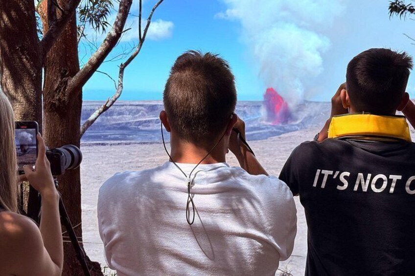 People observing a volcanic eruption with smoke and ash visible. 2