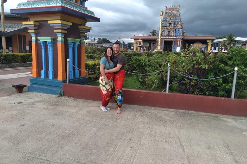 Una pareja posando frente a una estructura de templo colorida con diseño tradicional. 2