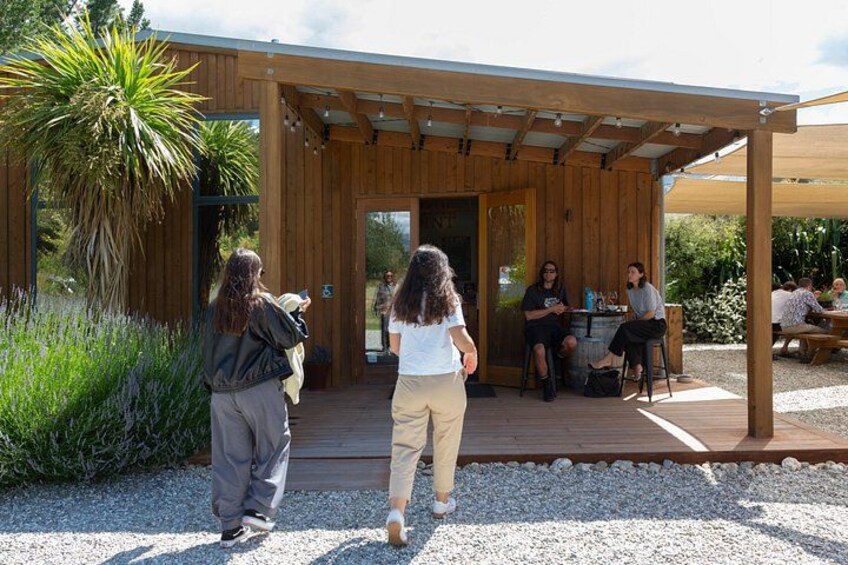 Ein hölzerner Pavillon mit sitzenden und stehenden Personen. 3