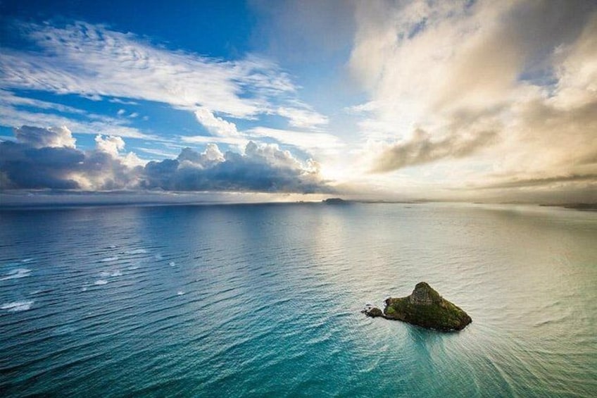 A calm sea with a small island in the distance. 2
