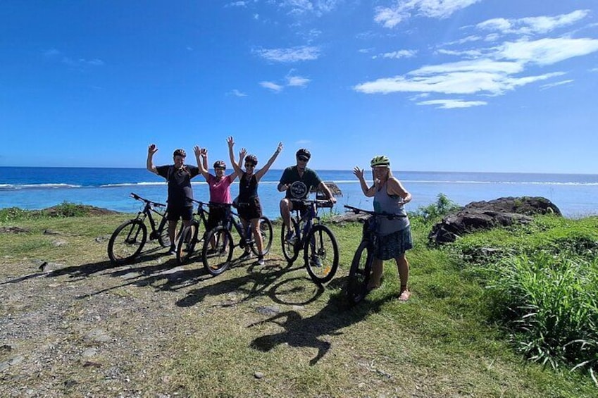 Un grupo de ciclistas en un camino costero con vistas al océano. 1