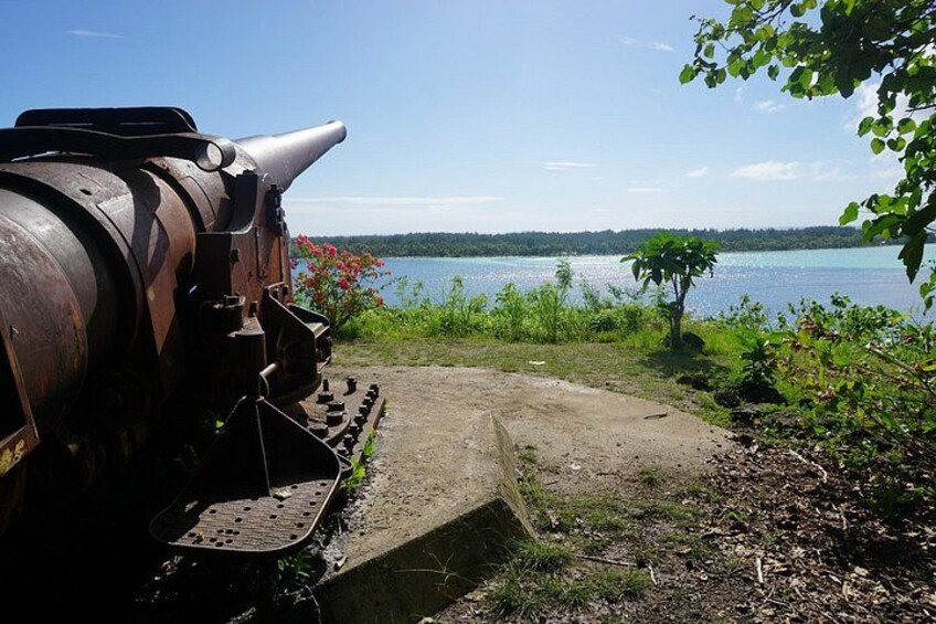 A rusty train engine, a concrete platform, and a lake with greenery. 4