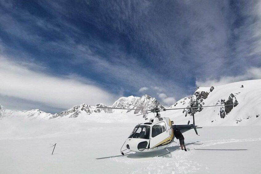 A helicopter on a snowy mountain with a clear sky. 3