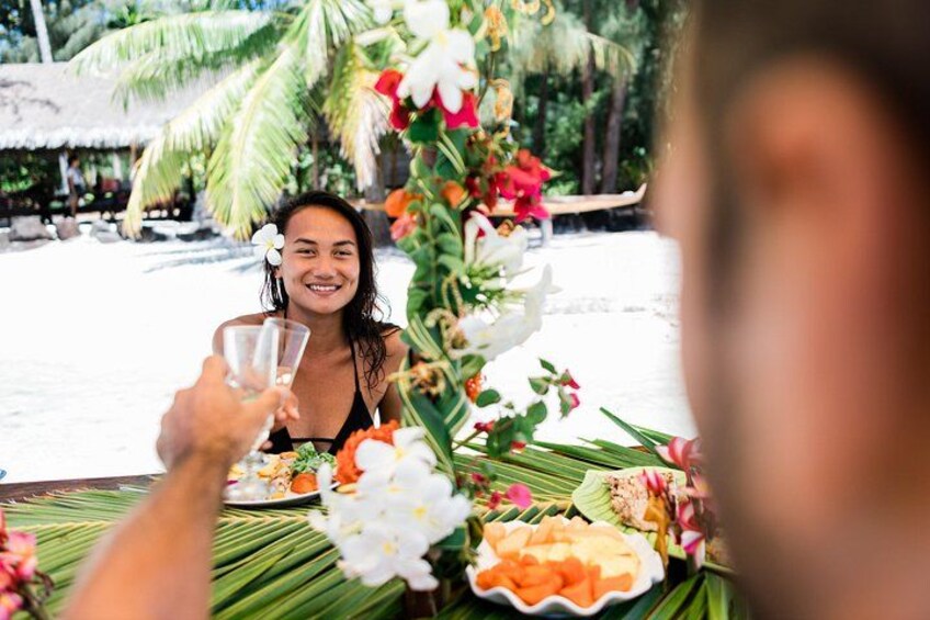 Un entorno tropical con una mesa de comedor decorada con flores y una variedad de frutas. 5
