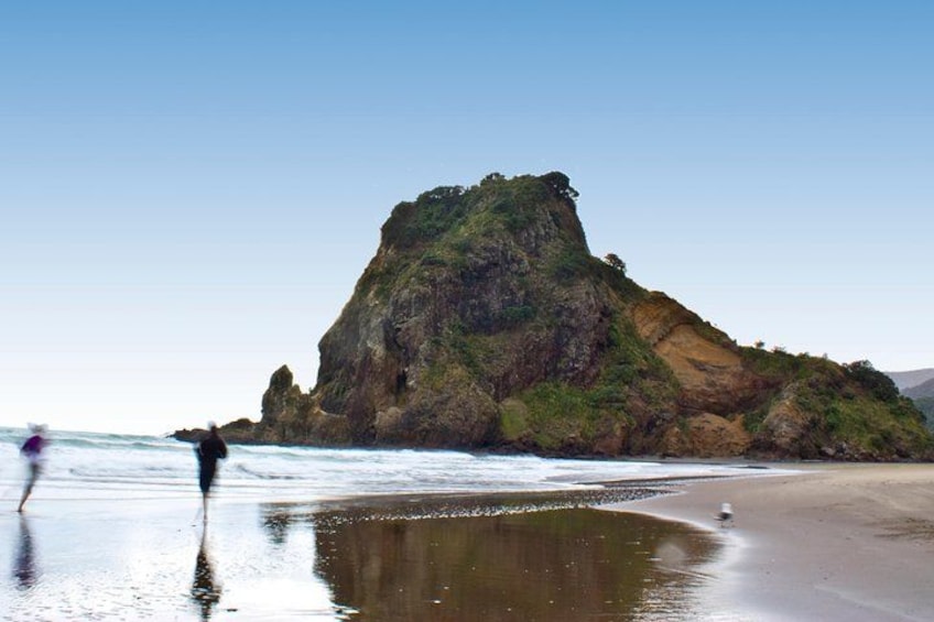 A rocky coastal landscape with a prominent cliff and a beach in the foreground. 4