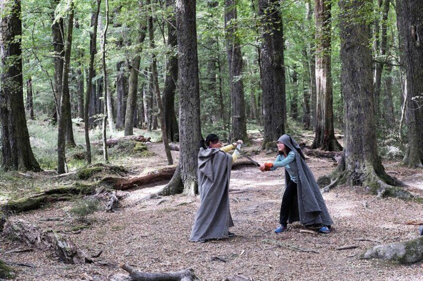 Zwei Personen in einem Wald, eine hält einen Schläger und die andere einen Ball. 3