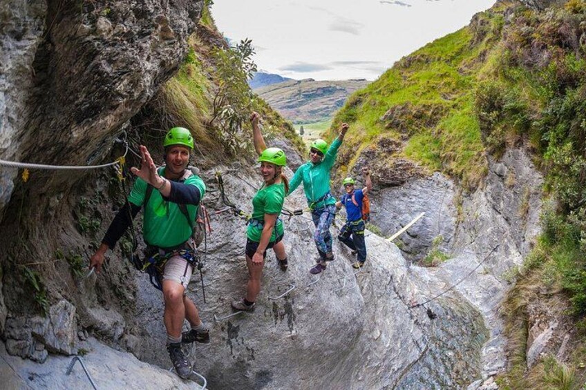 A group of people rappelling down a rocky cliff. 2