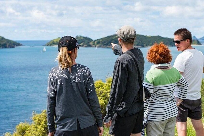 Un gruppo di persone in piedi vicino a un corso d'acqua, con delle colline sullo sfondo. 4