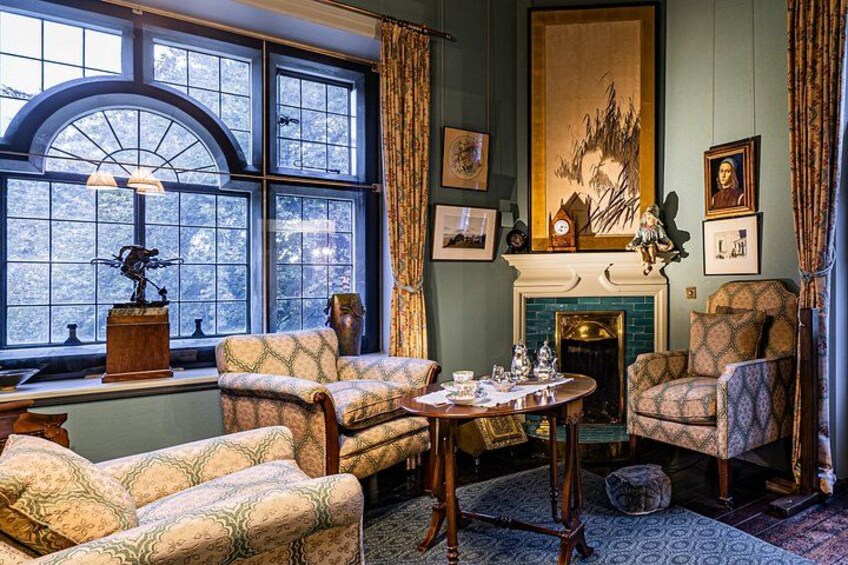 A traditional room with patterned furniture, a fireplace, and artwork on the walls. 3