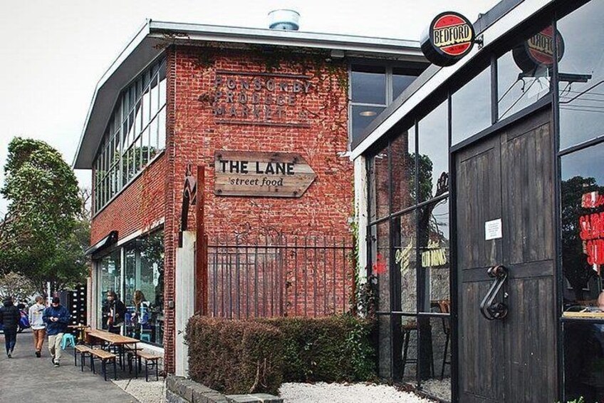 A brick building with a sign reading 'The Lane street food.' 2