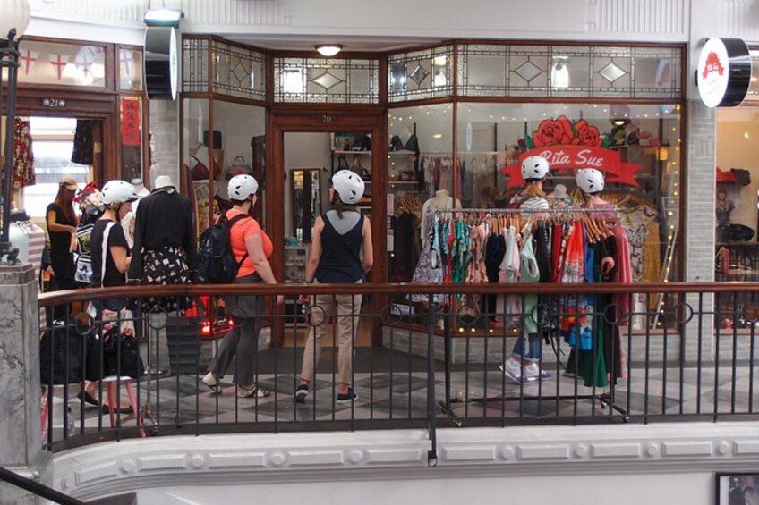 A shopping area with a store named 'Rita Sus' and a railing in the foreground. 3