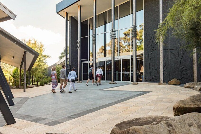 A modern building with large glass windows and a covered walkway. 3