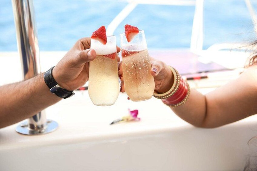 Två personer skålar med champagneglas, och ett av glasen är dekorerat med en jordgubbe. 4
