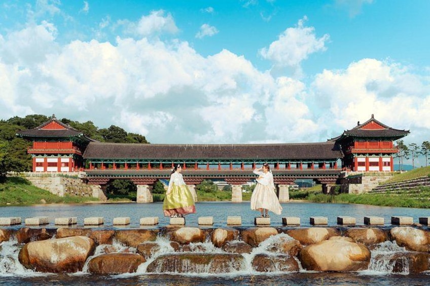 Un palais coréen traditionnel avec un pont enjambant une rivière. 1