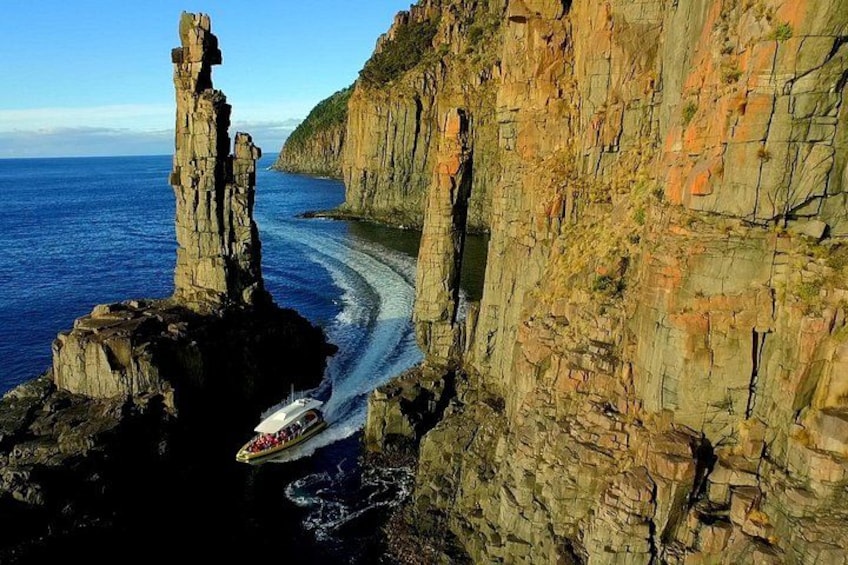 A boat navigating a narrow waterway between rocky cliffs. 1