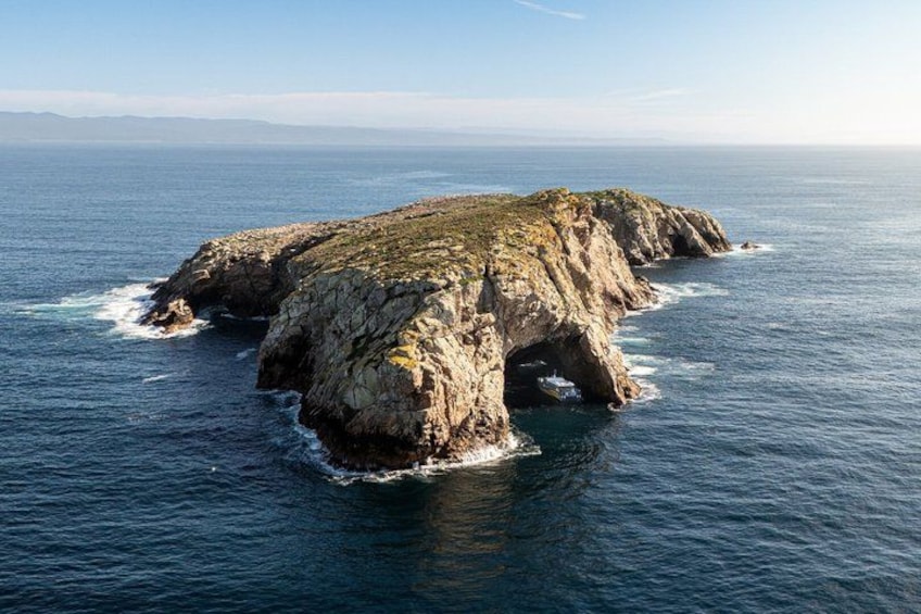 A rocky island surrounded by ocean waves. 4