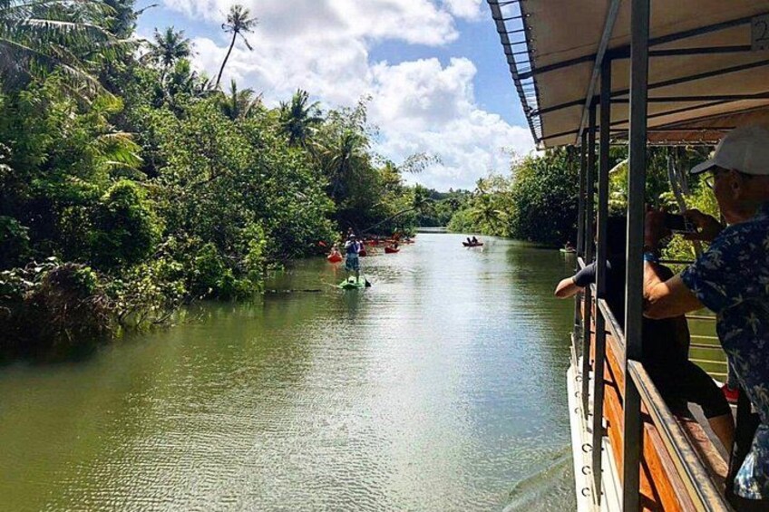 Un río con barcos, vegetación exuberante y cielo despejado. 4