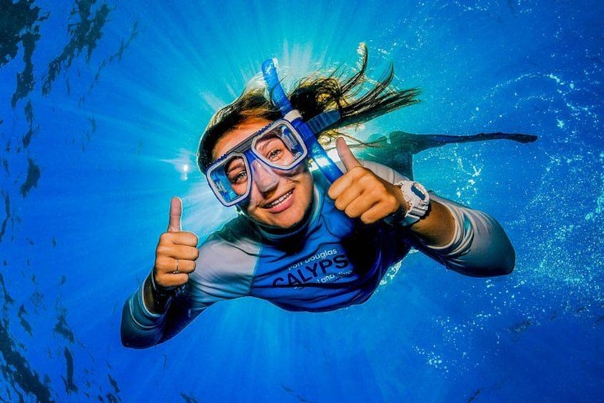 A person underwater, giving a thumbs-up, with a blue background. 4