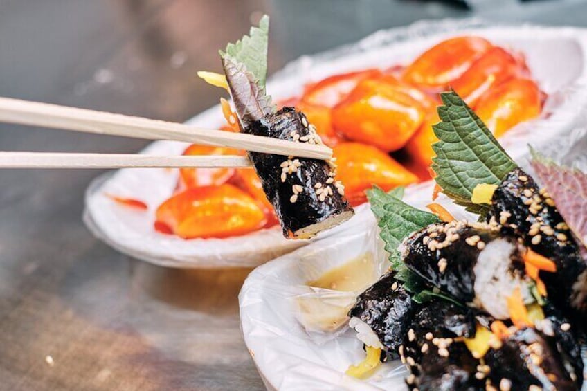 Sushi rolls with sesame seeds and wasabi, garnished with green leaves, on a plate. 5
