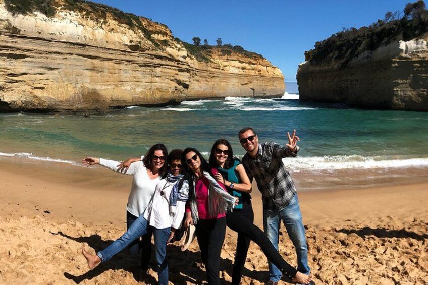 Un grupo de personas en una playa con acantilados al fondo. 3