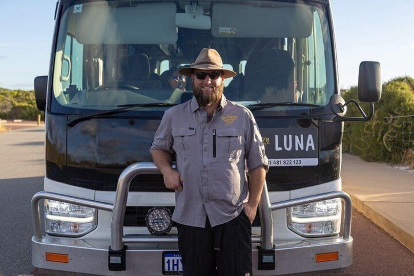 A man standing in front of a black truck with the license plate '1H' and the word 'LUNA' on the front. 2