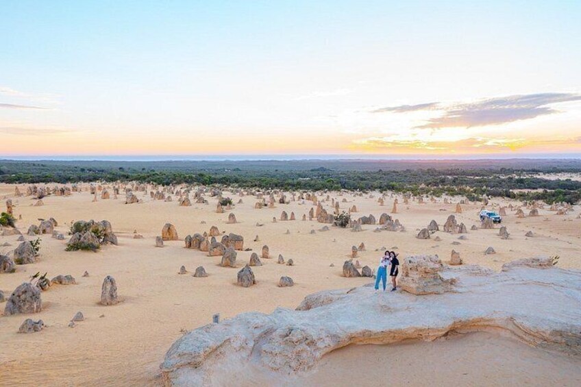 A desert landscape with numerous rock formations and a couple embracing. 1
