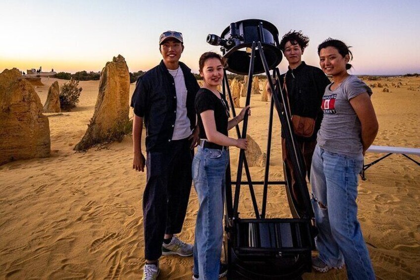 A group of people standing in a desert with large rock formations in the background. 4
