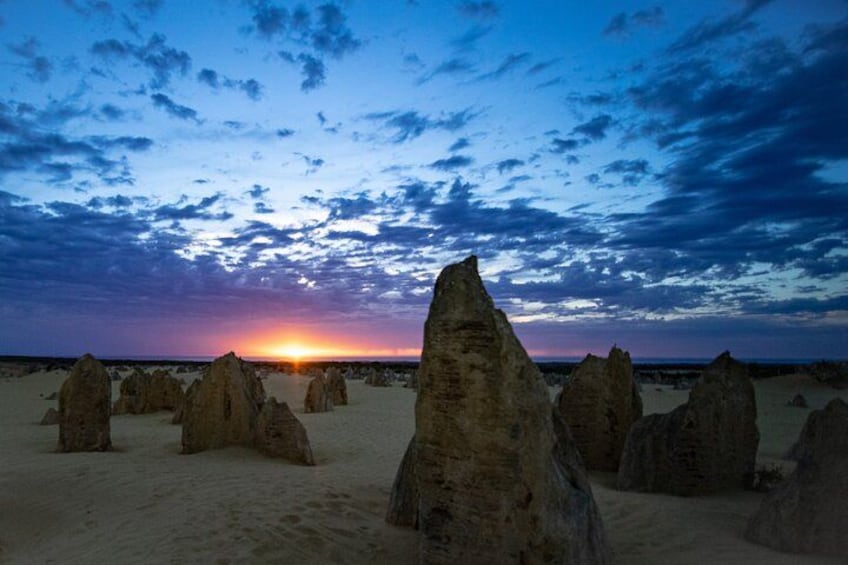 A desert landscape with prominent rock formations during sunset. 3