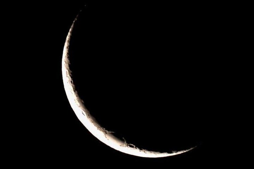 A crescent moon against a dark sky. 4