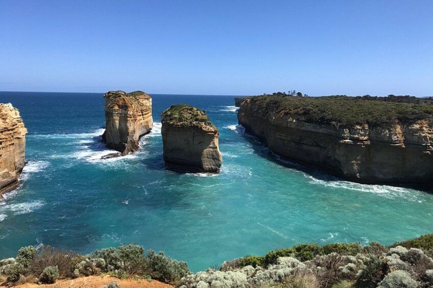 Un paysage côtier caractérisé par d’imposantes formations rocheuses et des eaux d’un bleu limpide. 4