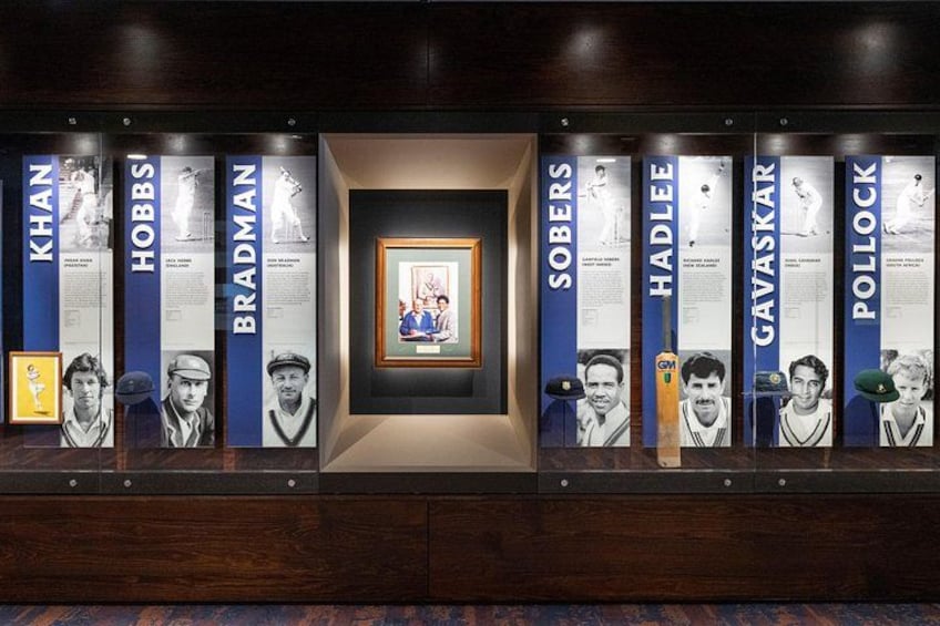 A display of cricket memorabilia with framed photos and text. 2