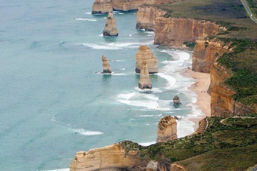 A coastal landscape with prominent rock formations and a beach. 4