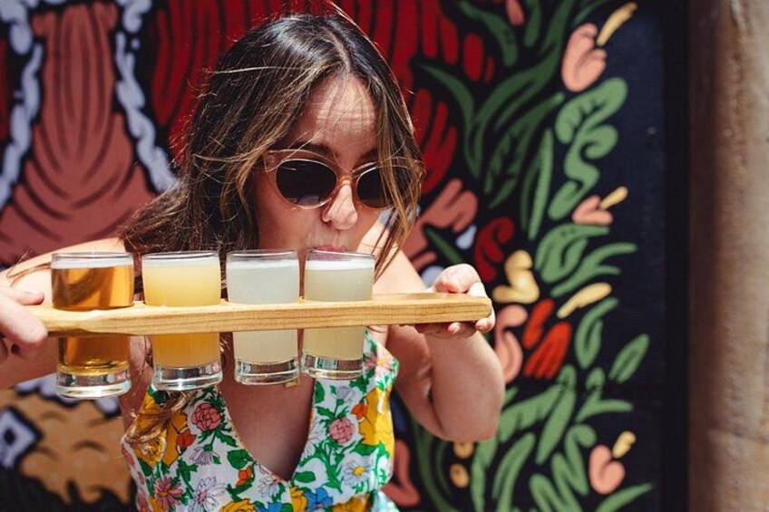 Una persona sosteniendo una bandeja con cuatro vasos de diferentes bebidas. 3