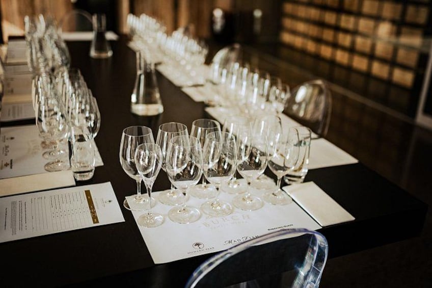 Una larga mesa con varias copas de vino y menús. 5
