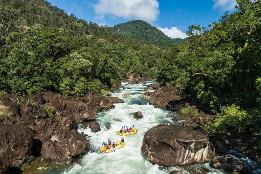 Une rivière aux courants rapides, bordée d’une forêt dense et d’un paysage rocheux. 1