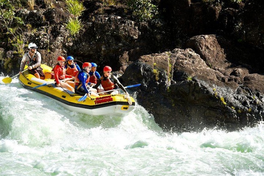 Un groupe de personnes à bord d’un radeau jaune navigue sur une rivière aux rapides tumultueux. 5