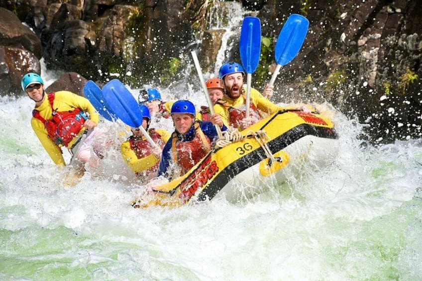 Un groupe de personnes à bord d’un radeau jaune naviguant dans des rapides aux eaux tumultueuses. 4