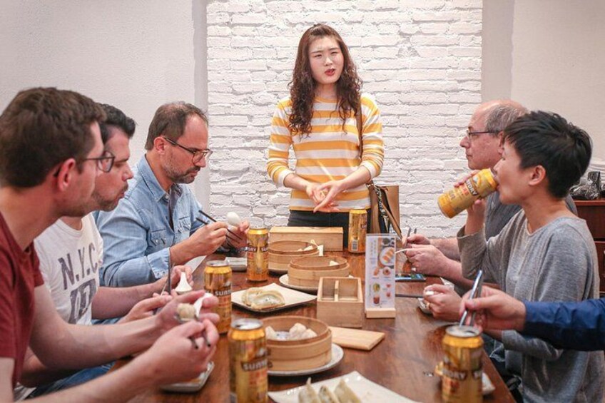 Een groep mensen zit rond een tafel met eten en drinken, en geniet van een gezellig samenzijn. 2