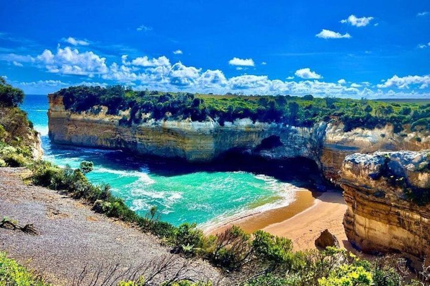 Eine Küstenlandschaft mit Klippen, einem Strand und klarem, blauem Wasser. 4