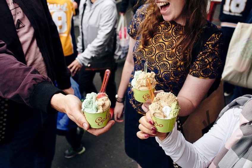People holding green cups with ice cream scoops and spoons. 1